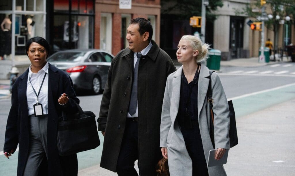 Three professionals walking and talking on a city street